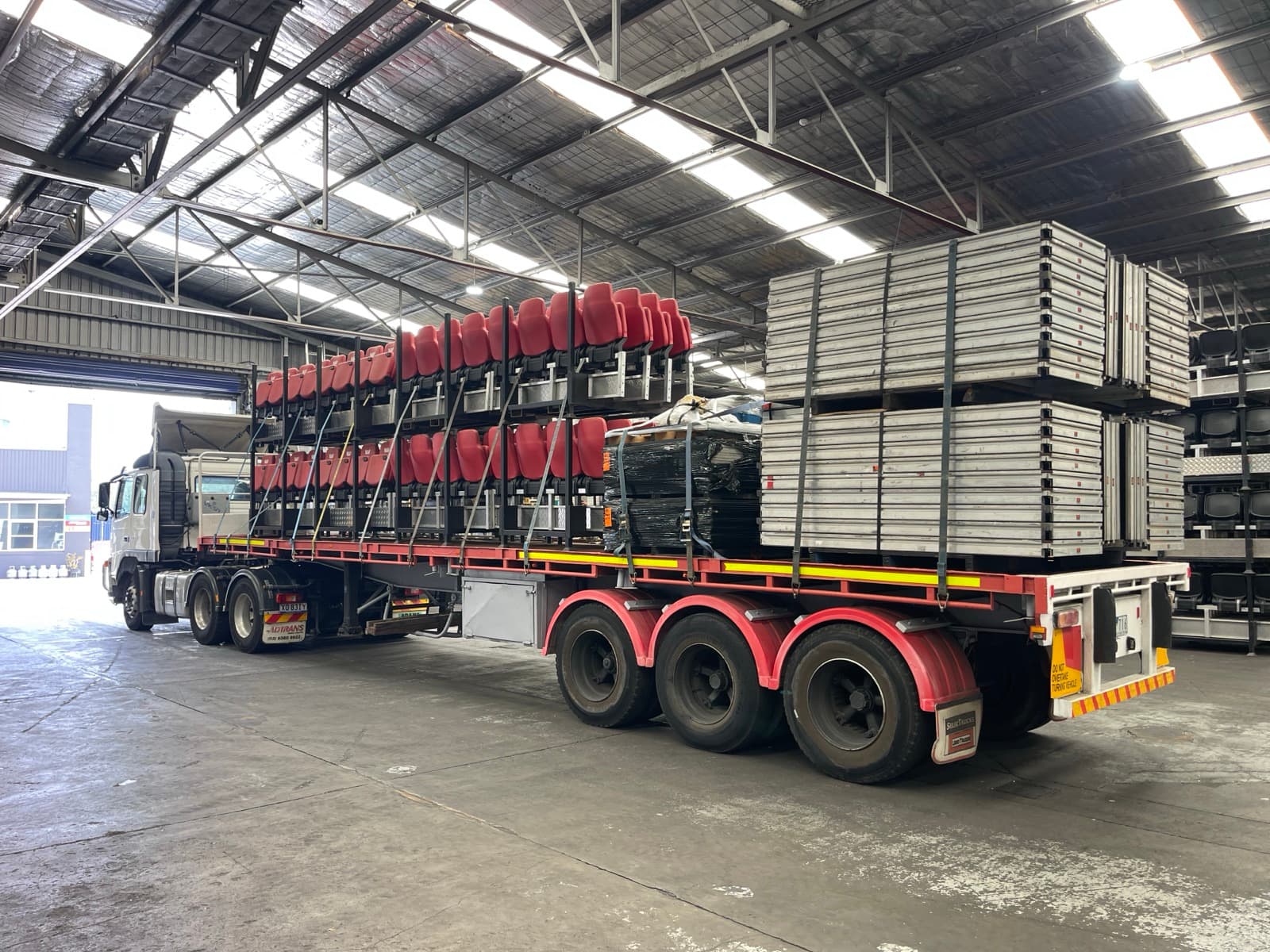 Quick Cargo semi-trailer loaded with event staging and seating in the warehouse