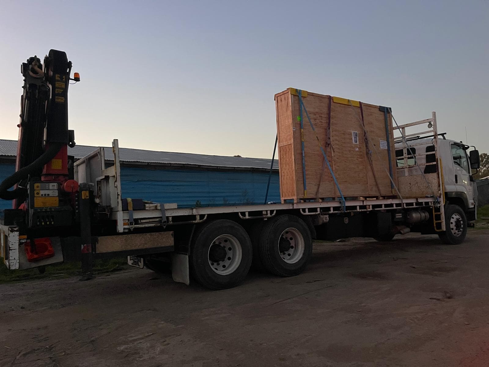 HIAB truck loaded with a large crate secured on its open deck