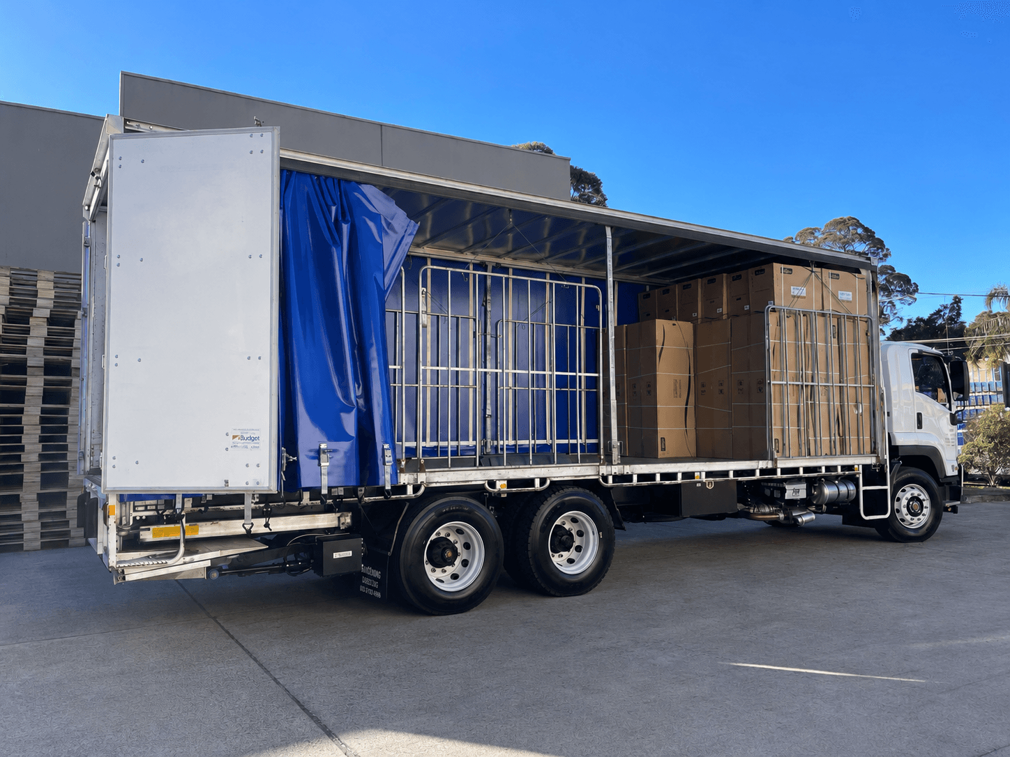 Quick Cargo tautliner truck with its curtain pulled back showing palletised freight